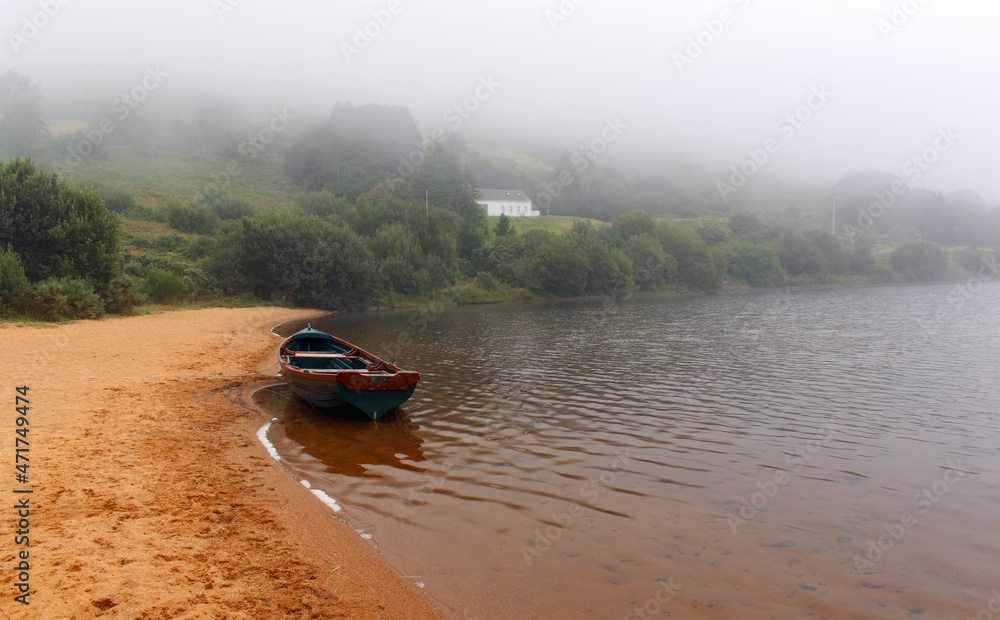 Beautiful landscape scenery of old wooden fishing boat on the sandy beach of Loch Na Fooey in connemara National park in county Galway, Ireland Beautiful landscape scenery of old wooden fishing boat on the sandy beach of Loch Na Fooey in connemara National park in county Galway, Ireland