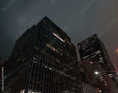 Modern city building office at night. Low angle view of skyscrapers. Looking up perspective. Bottom view of modern skyscrapers in a business district. Cityscape at night. photo