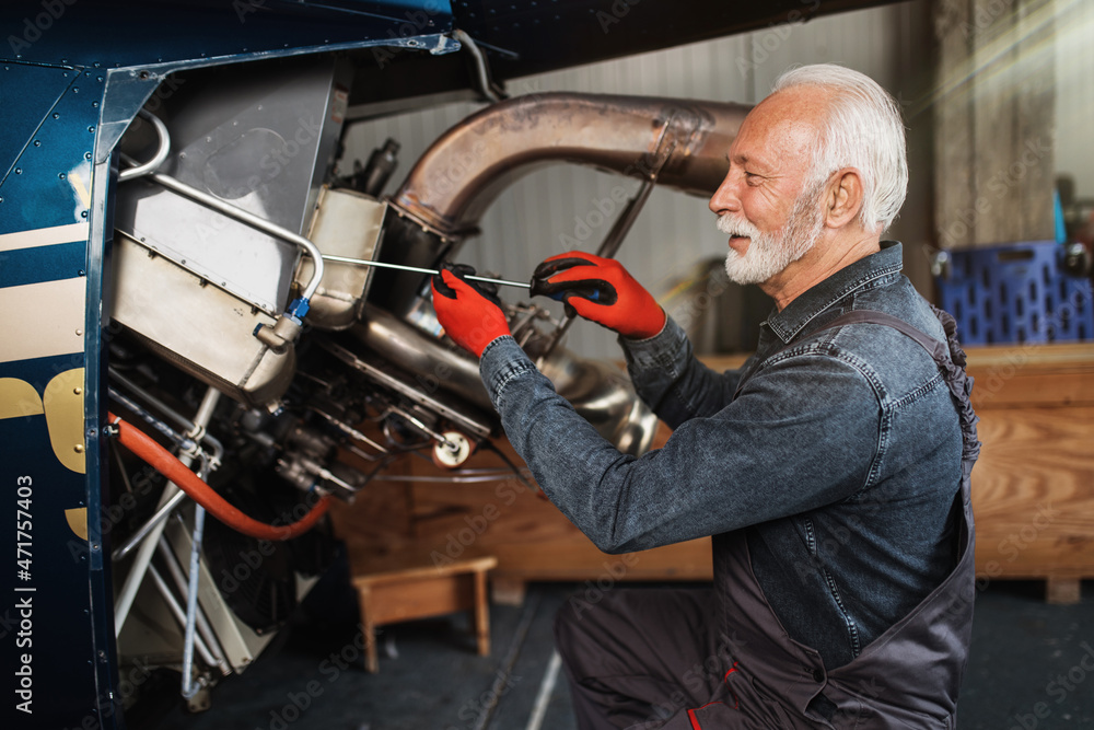 Professional senior helicopter mechanic working in air vehicle repair service. Professional senior helicopter mechanic working in air vehicle repair service.