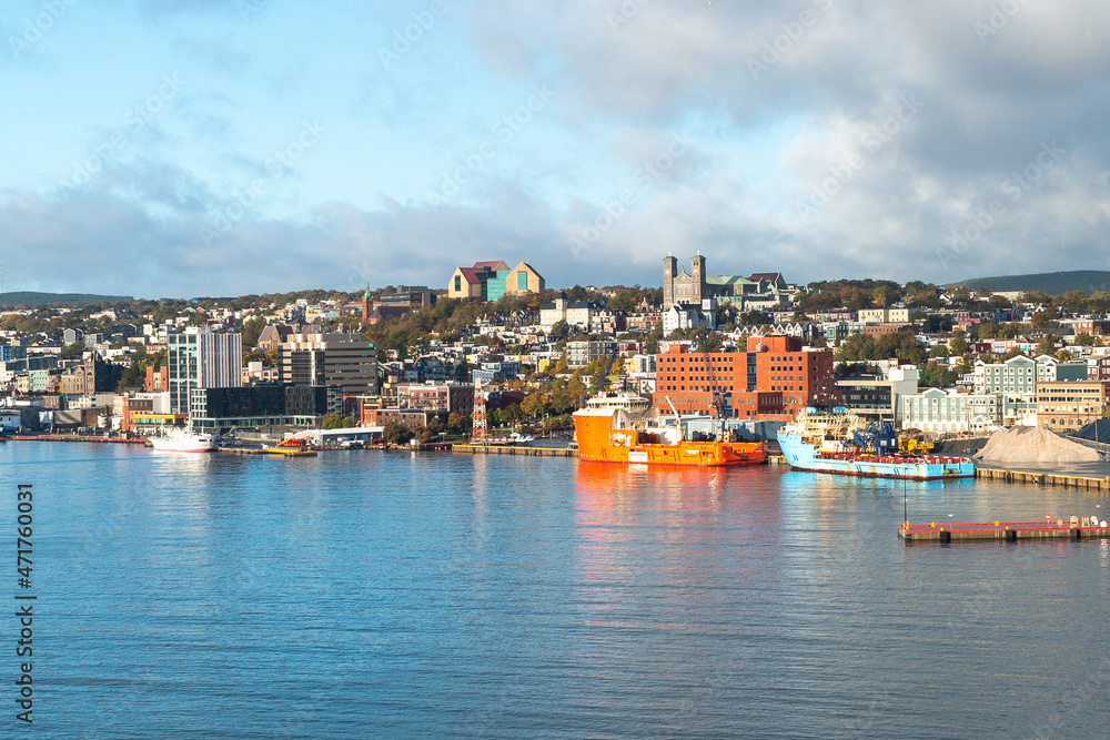 St. John's, Newfoundland, Canada - November 2021: Colorful downtown St. John's with historic wooden residential, commercial, business,and Federal Government buildings. There are colorful ships docked.