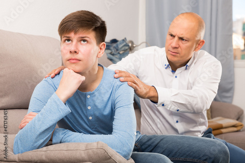 Father comforting teen son after discord at home