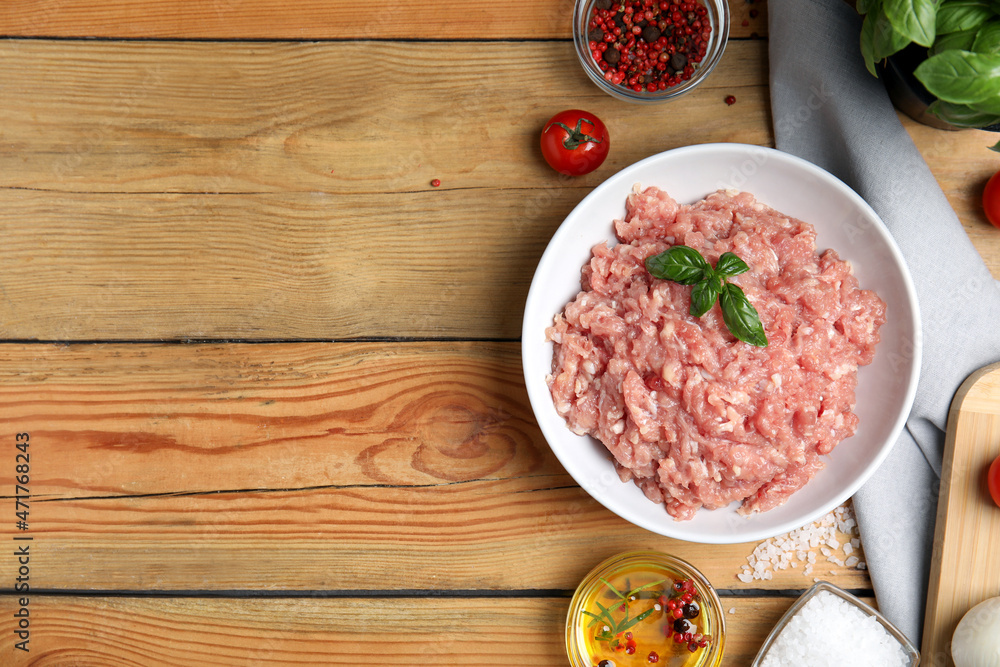 Raw chicken minced meat and ingredients on wooden table, flat lay. Space for text Raw chicken minced meat and ingredients on wooden table, flat lay. Space for text