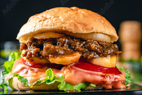 Fresh grilled homemade burgers with beef, tomato, fried egg, cheese and lettuce on rustic wooden background. fast food and junk food concept. fresh tasty burger on dark background.