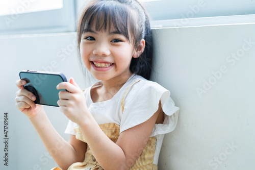 Asian child using smartphone at home