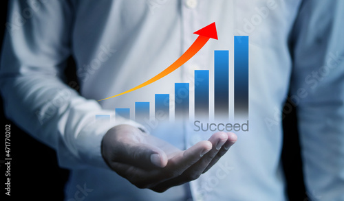 businessman holding a successful graph