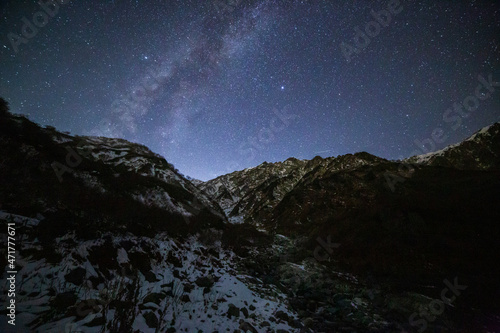 晩秋の白馬大雪渓から月光に照らされた雪の白馬岳と星空