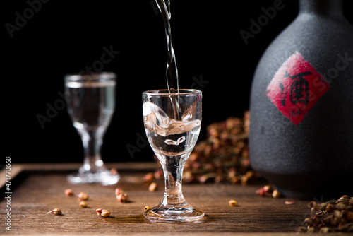 Bild auf Leinwand chinese liquor is pouring into a glass from a bottle on table