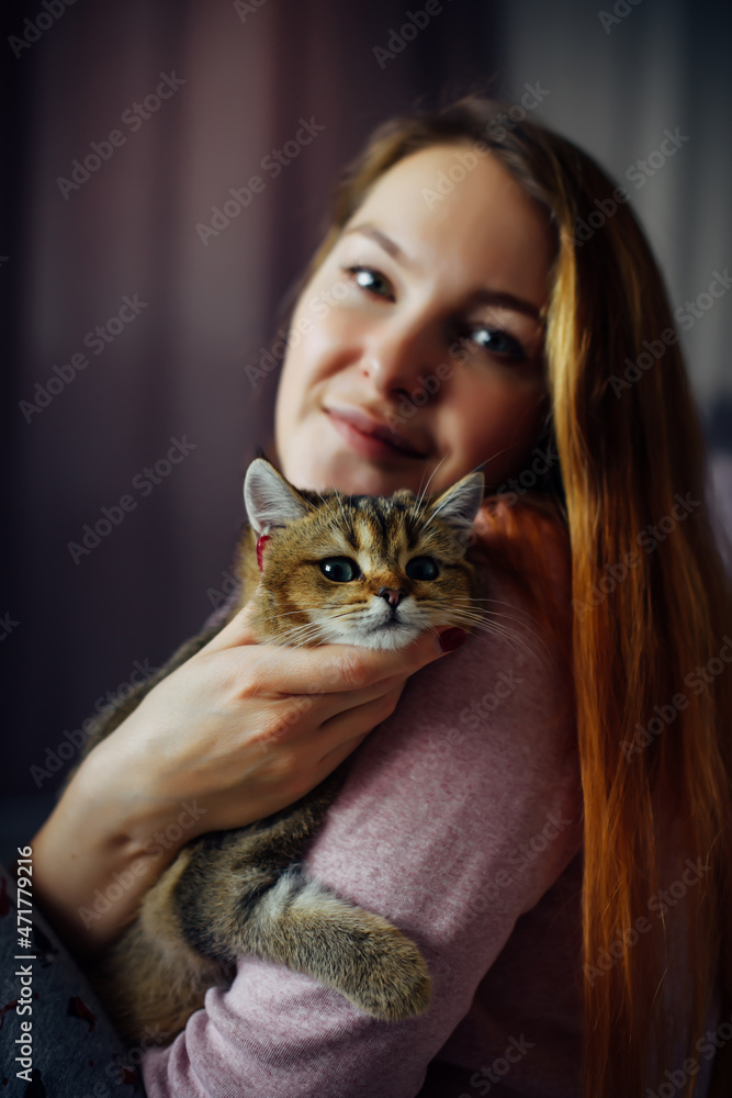Portrait of attractive woman holding funny ginger kitten with green eyes. Female hugging lovely cat. Focus on pet. Portrait of attractive woman holding funny ginger kitten with green eyes. Female hugging lovely cat. Focus on pet.
