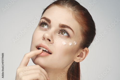 woman with bare shoulders face cream skin care close-up