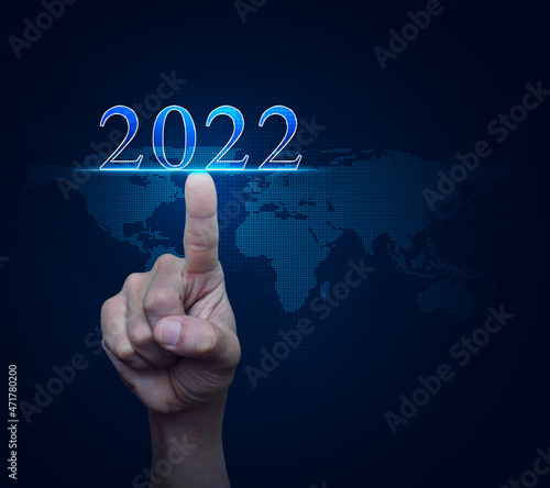 Hand pressing 2022 text over digital world map technology style, Business happy new year 2022 cover concept, Elements of this image furnished by NASA