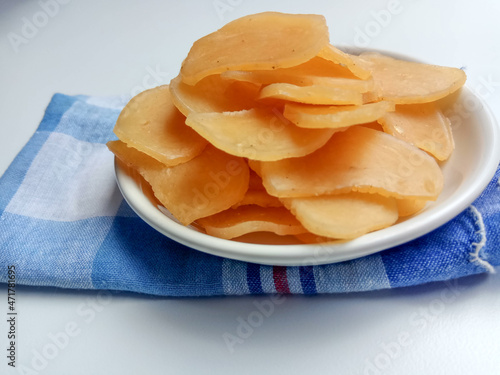 Kerupuk terigu, or flour crackers, before frying. A complement for Indonesian food, or as a snack. Placed inside a white bowl. photo