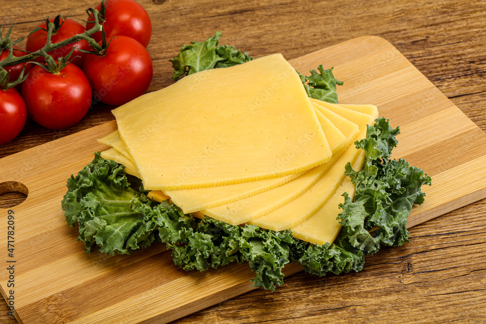 Sliced Gauda cheese over board Sliced Gauda cheese over board