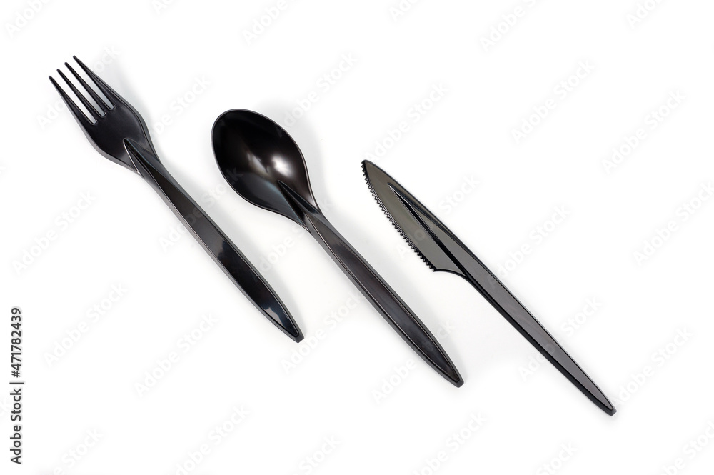 A set of plastic cutlery knife, fork and spoon in black, filmed on a white background A set of plastic cutlery knife, fork and spoon in black, filmed on a white background