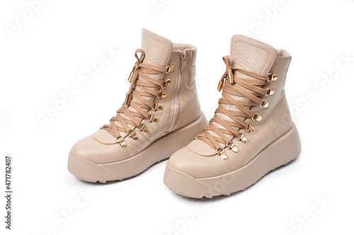 Womens beige leather boots with zip and lacing  photographed against a white background.