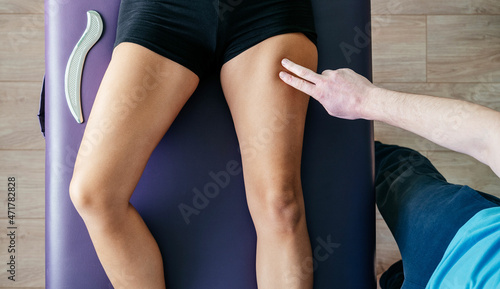 Osteopath performing myofascial release for quadriceps