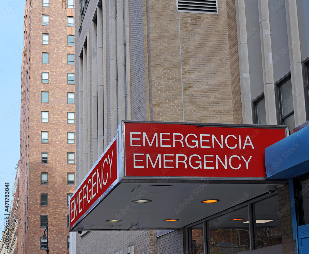 Hospital emergency entrance sign, bilingual in English and Spanish