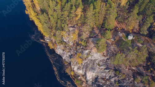 Aerial drone view on Yastrebinoe lake and cliffs. Beautiful season landscape with a lake or river water and larch trees. Russia, Karelia.