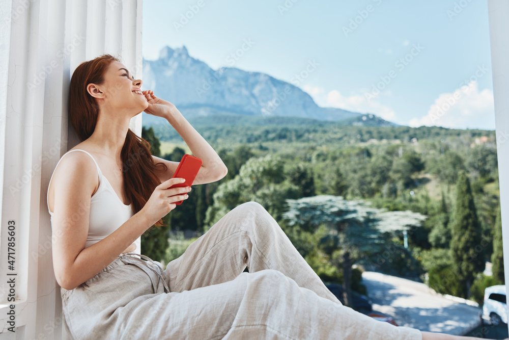 beautiful woman use the phone looks at the screen in a comfortable hotel an open view of the Relaxation concept beautiful woman use the phone looks at the screen in a comfortable hotel an open view of the Relaxation concept