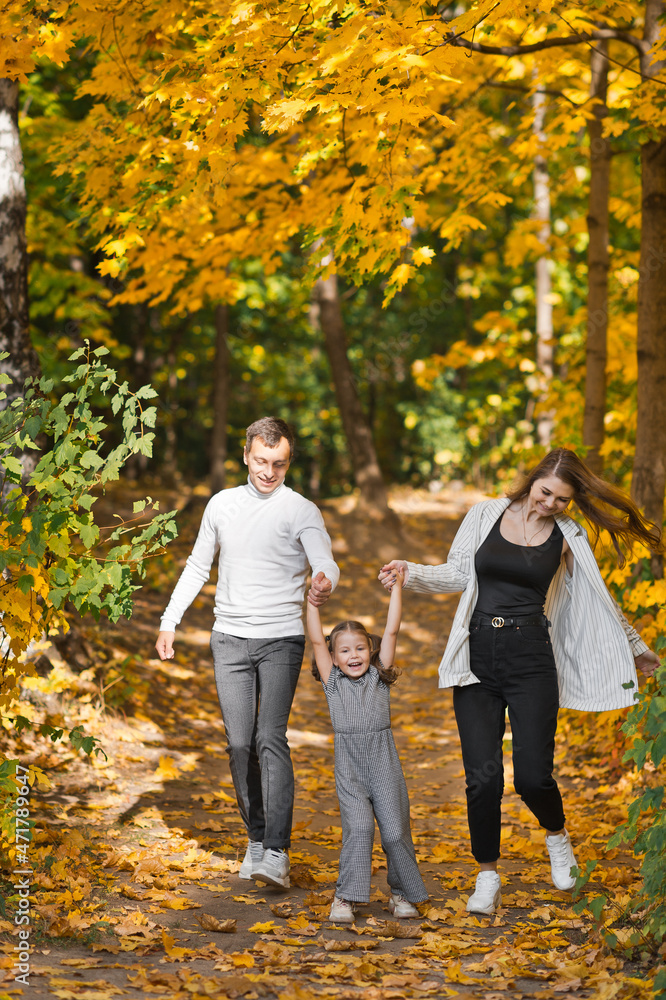 Obraz premium Autumn walk of a young family in the forest 3373.