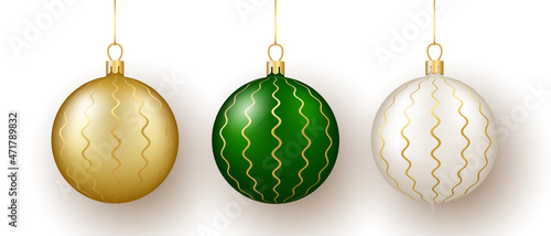 Christmas and New Year decor. Set of gold, white and green glass wavy ornament balls on ribbon with bow.