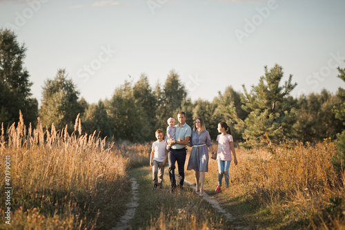 A large family is walking along a meadow road 3472.