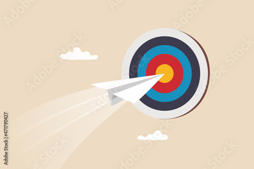 Business goal or target, challenge or improvement to achieve success, win business competition or motivation concept, paper plane origami flying through dartboard or archer bullseye target. photo