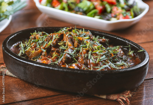 Oriental food, delicious meat sauté in a traditional frying pan.