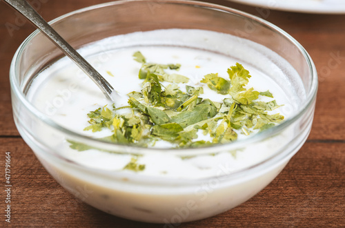 yogurt soup with herbs in a plate on a wooden table.spas
