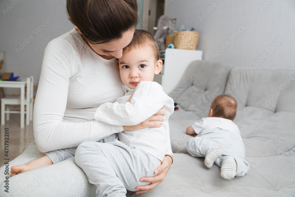 mom plays and reads books with two  little kids. mother spends time with two child sons at home.  place for text. copy space. family time at home
