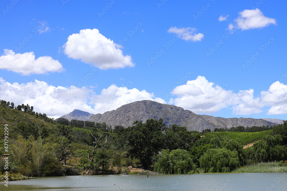 A view over a dam with white clouds and mountains