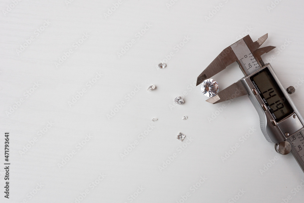 a lot of diamonds and a measuring device in a jewelry workshop a lot of diamonds and a measuring device in a jewelry workshop