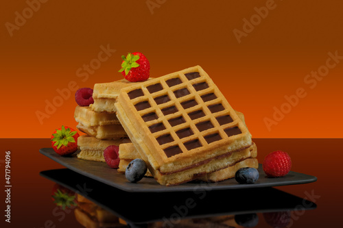 Waffles With Fruit and Maple Syrup on Colored Background