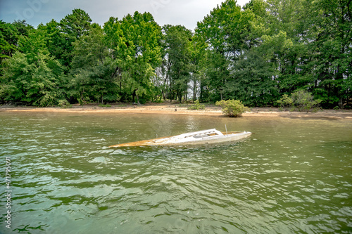 Fotografie dirty sunken boat floating in the lake