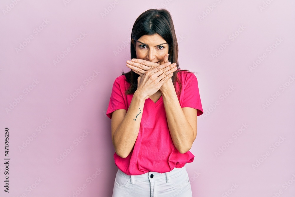 Young hispanic woman wearing casual clothes shocked covering mouth with hands for mistake. secret concept. Young hispanic woman wearing casual clothes shocked covering mouth with hands for mistake. secret concept.