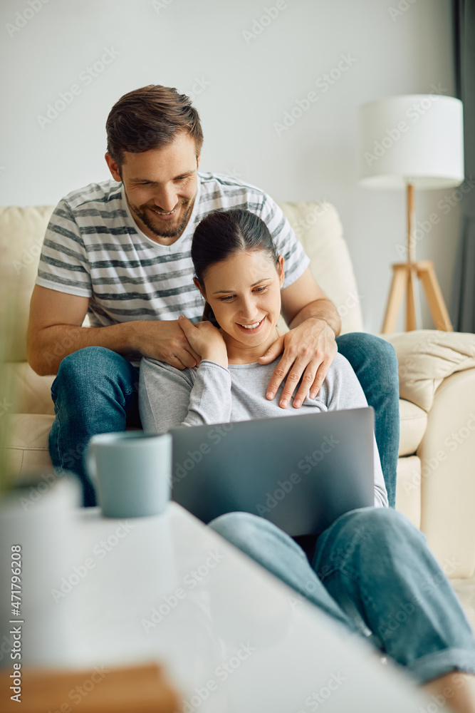 Happy couple surfing the net on laptop while relaxing at home. Happy couple surfing the net on laptop while relaxing at home.