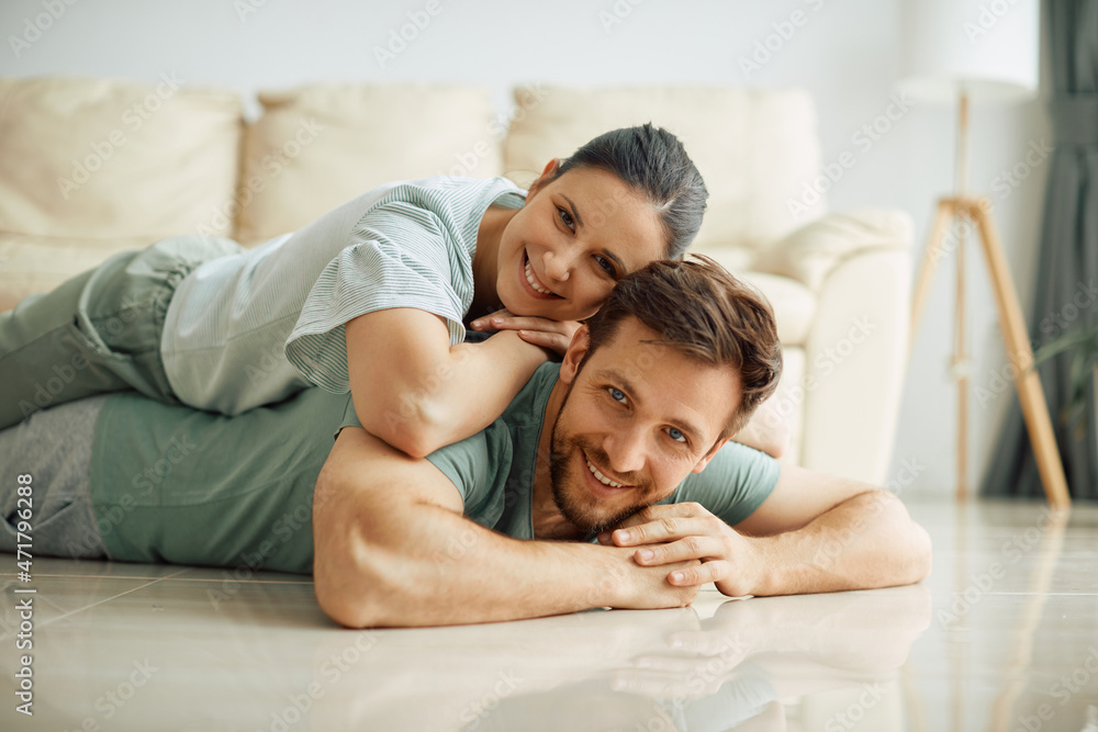 Happy couple relaxes on floor at their new home and looking at camera. Happy couple relaxes on floor at their new home and looking at camera.