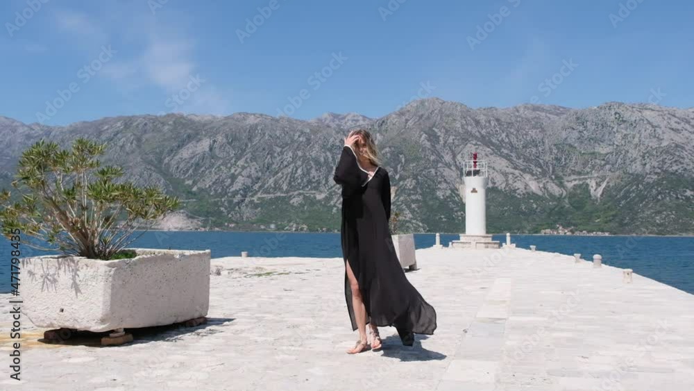 Portrait of gorgeous girl looking to camera. tall sexy brunette woman. woman in blue dress blowing her hair in the wind. mysterious beautiful woman outdoors Portrait of gorgeous girl looking to camera. tall sexy brunette woman. woman in blue dress blowing her hair in the wind. mysterious beautiful woman outdoors
