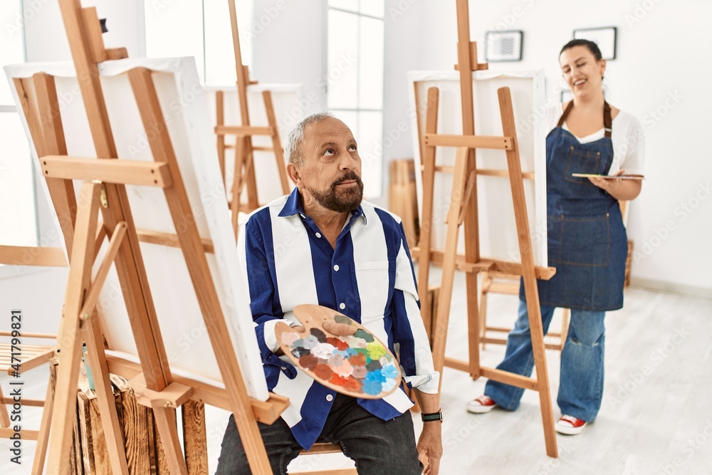Senior artist man at art studio smiling looking to the side and staring away thinking. Senior artist man at art studio smiling looking to the side and staring away thinking.