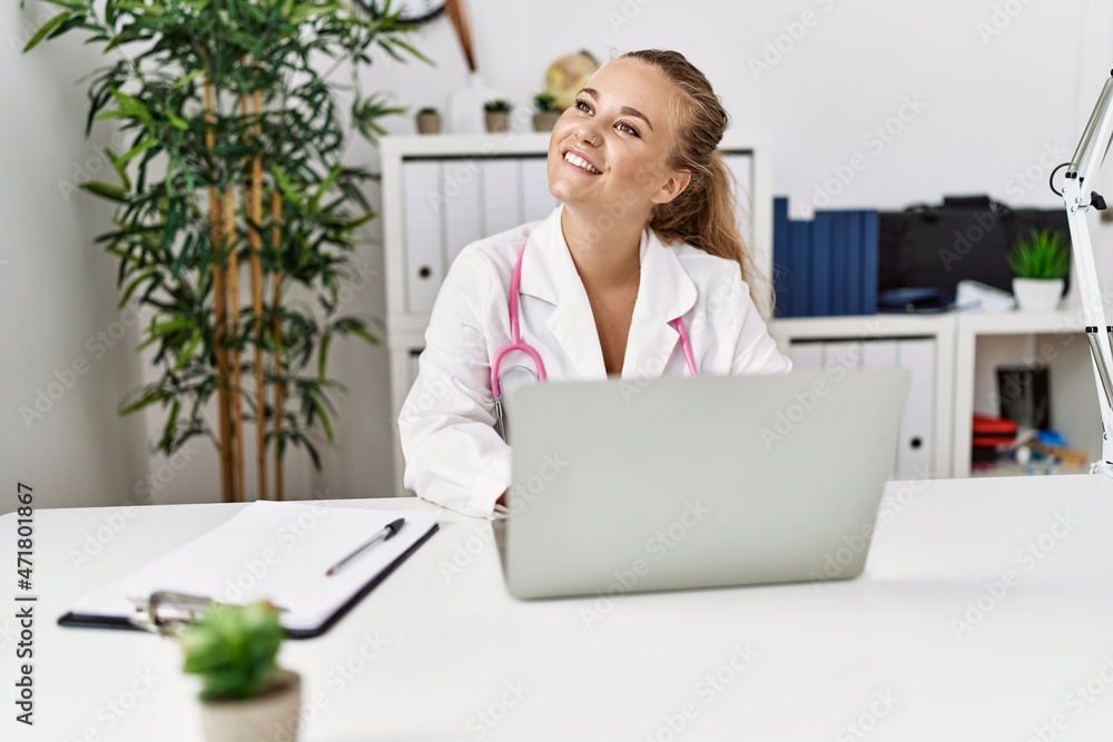 Young blonde girl wearing doctor uniform working at clinic Young blonde girl wearing doctor uniform working at clinic