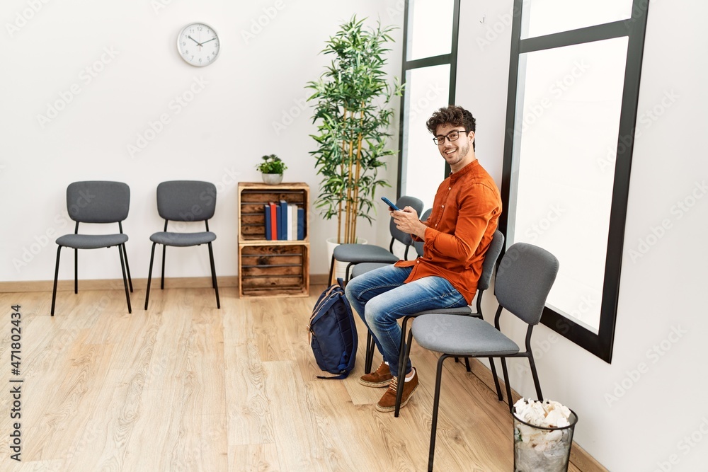 Young hispanic man smiling confident using smartphone at waiting room Young hispanic man smiling confident using smartphone at waiting room