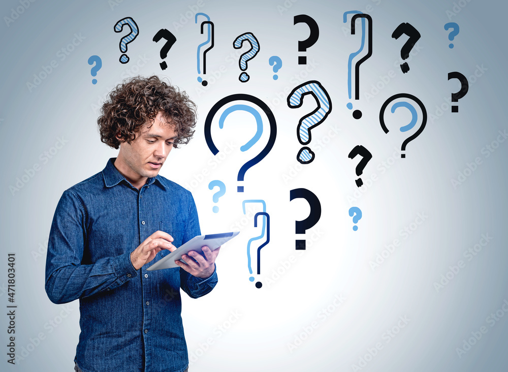 Businessman with tablet in hands working and set of question mar Businessman with tablet in hands working and set of question mar