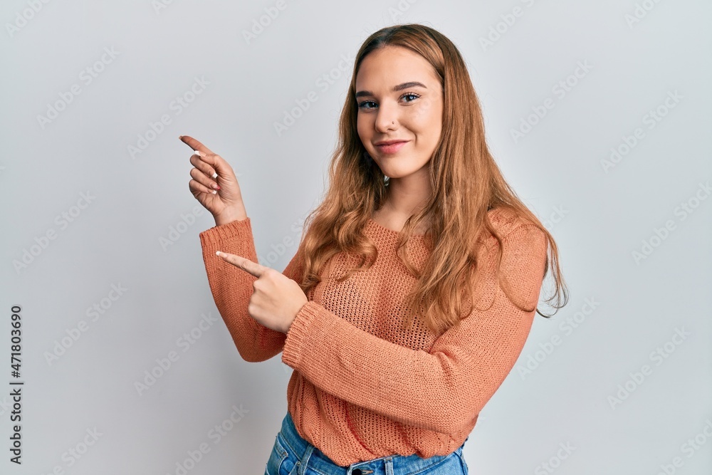 Young blonde woman wearing casual clothes smiling and looking at the camera pointing with two hands and fingers to the side. Young blonde woman wearing casual clothes smiling and looking at the camera pointing with two hands and fingers to the side.