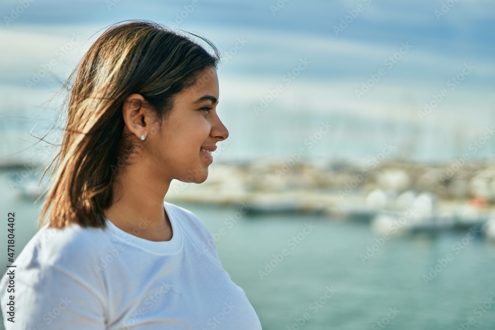 Young latin girl smiling happy standing at the beach. Young latin girl smiling happy standing at the beach.