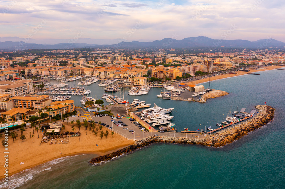 Aerial view of seaside area of French town of Frejus on Mediterranean coast overlooking residential houses and marina for pleasure yachts in summer