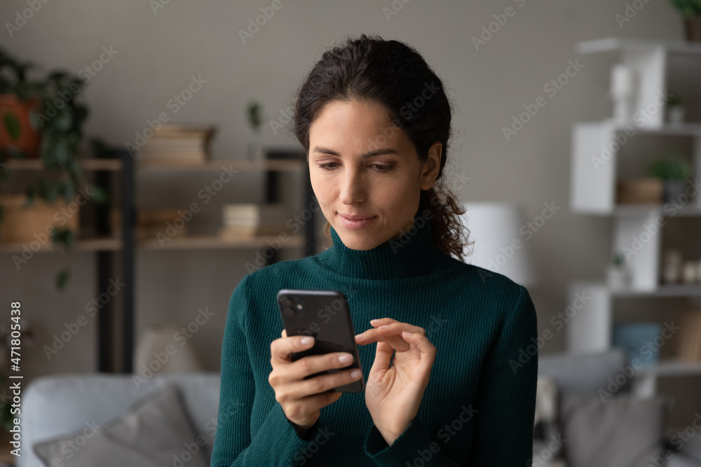 Enjoy modern tech. Focused millennial latin female use smartphone to work at internet browse information read news at social media. Calm confident young lady user text in mobile app check new messages Enjoy modern tech. Focused millennial latin female use smartphone to work at internet browse information read news at social media. Calm confident young lady user text in mobile app check new messages