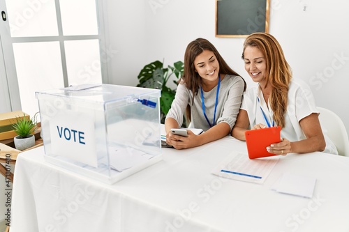 Obraz na plátne Mother and daughter smiling confident using touchpad working at electoral colleg