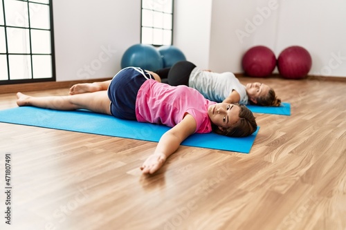 Mother and daughter stretching at sport center