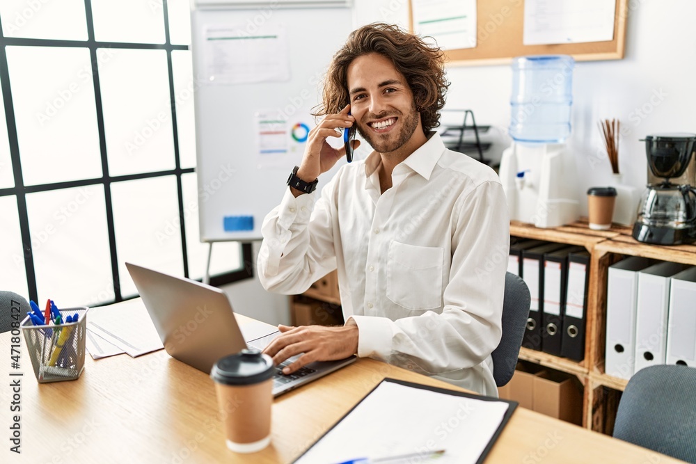 Young hispanic businessman smiling happy talking on the smartphone at office. Young hispanic businessman smiling happy talking on the smartphone at office.