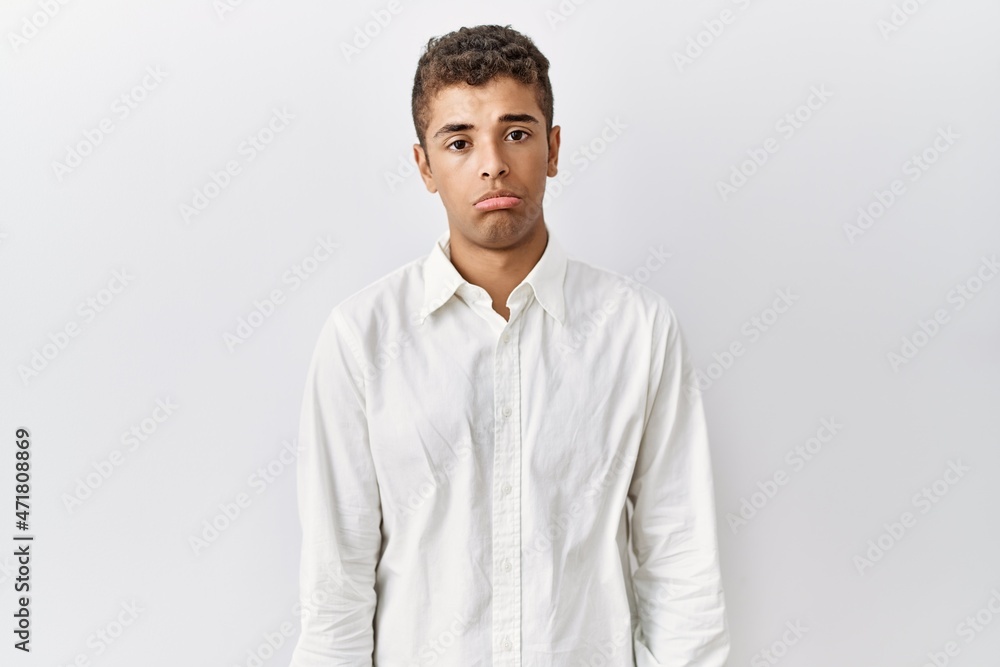 Young handsome hispanic man standing over isolated background depressed and worry for distress, crying angry and afraid. sad expression. Young handsome hispanic man standing over isolated background depressed and worry for distress, crying angry and afraid. sad expression.