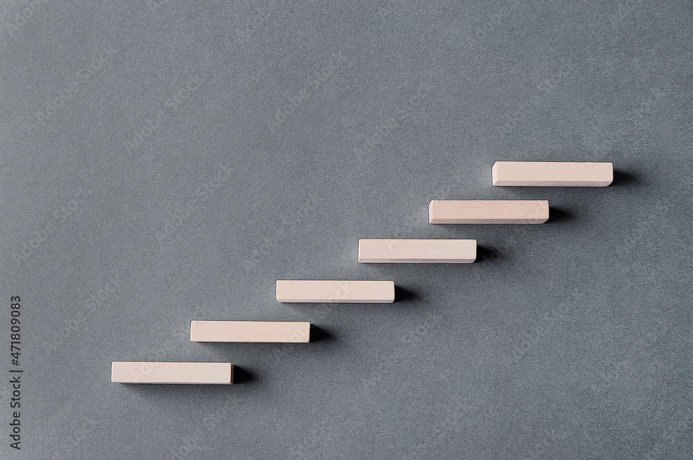 Steps from wooden blocks on a gray background with a shadow. Concept. Rise up. Height. Steps from wooden blocks on a gray background with a shadow. Concept. Rise up. Height.